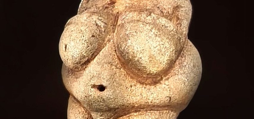 Небольшая палеолитическая фигурка Венеры Виллендорфской в музейной витрине